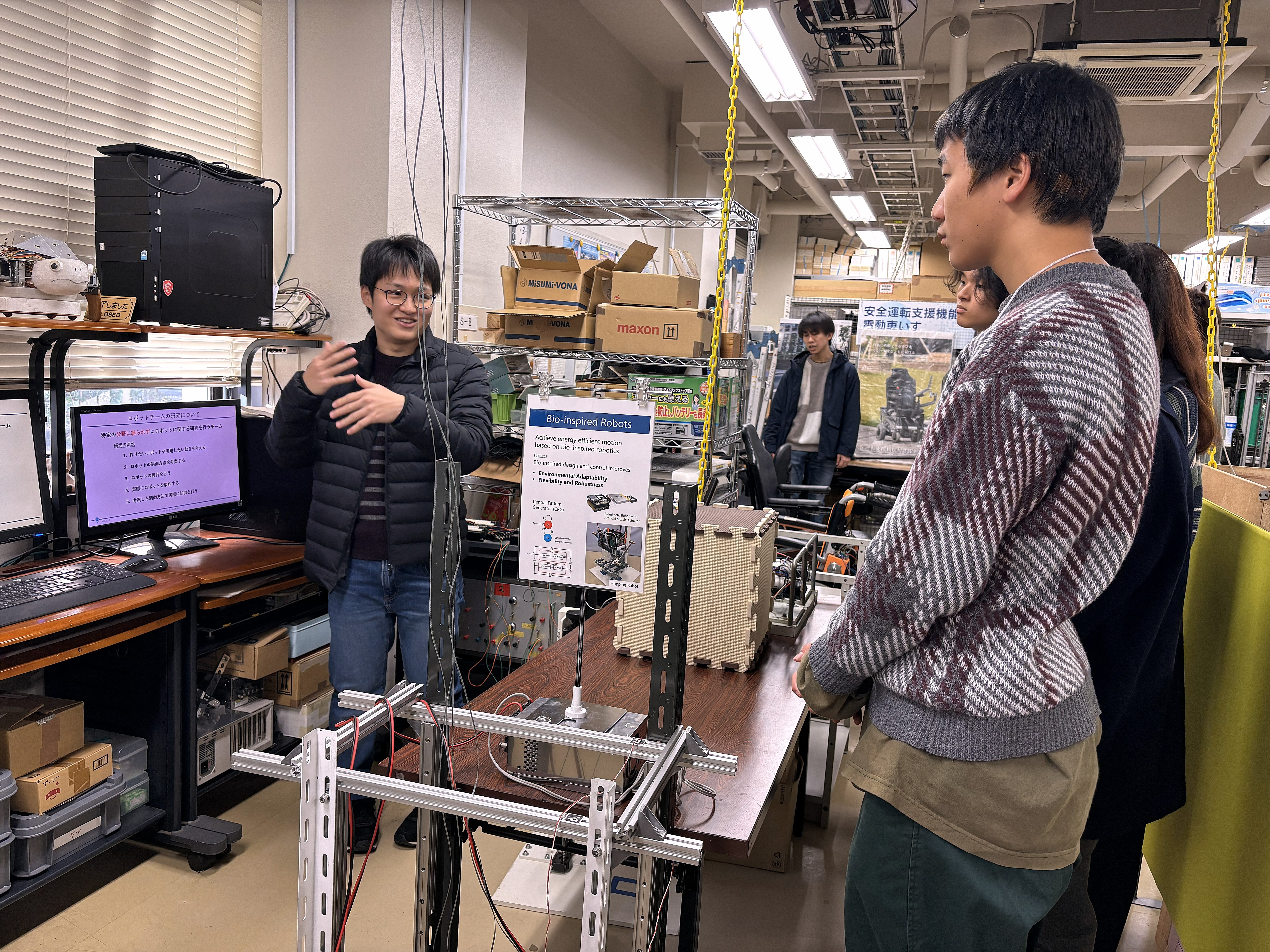 理工学部見学（大学院生の説明を熱心に聞く参加者）