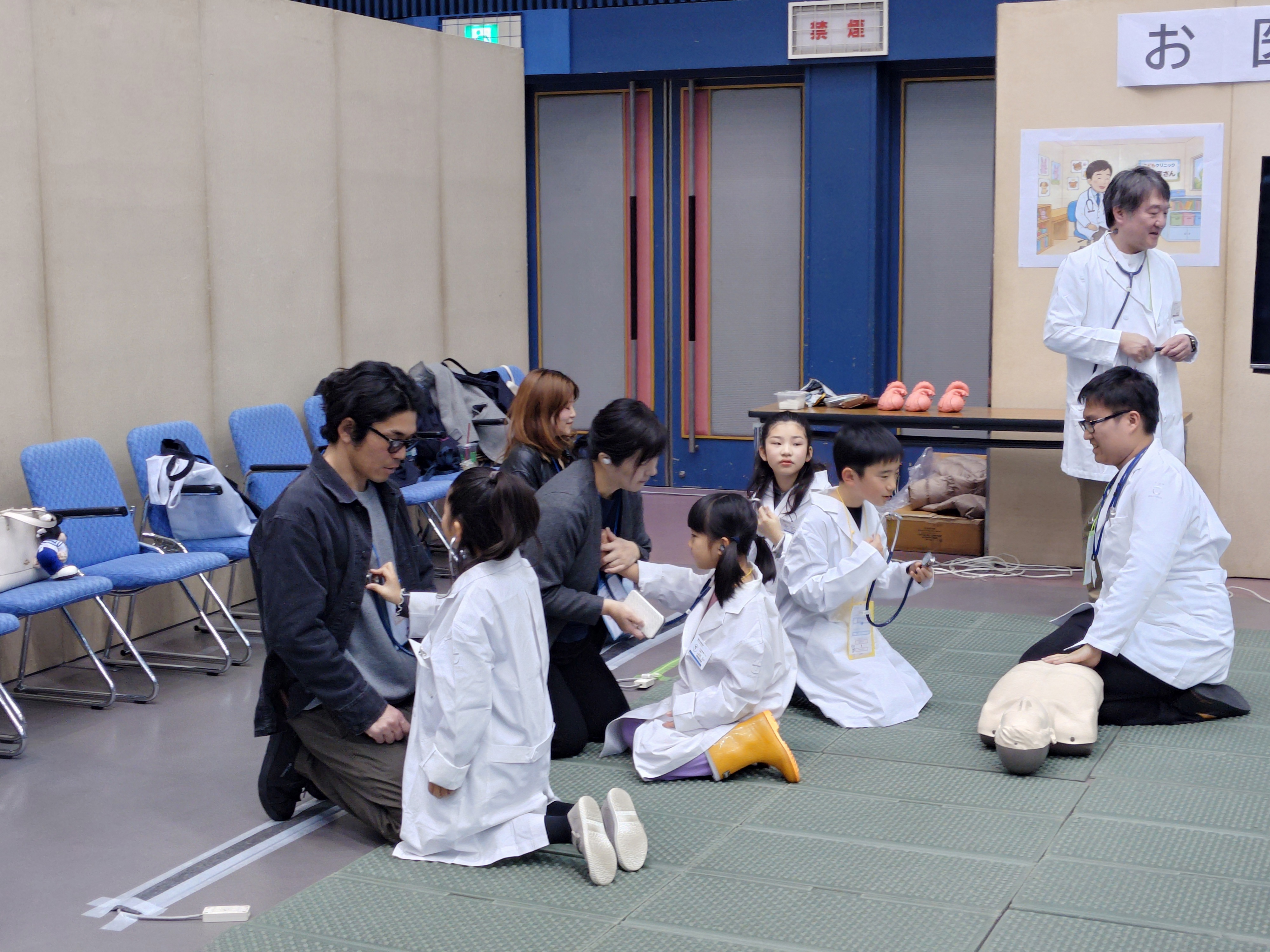 聴診器で保護者の心音を聞く小学生