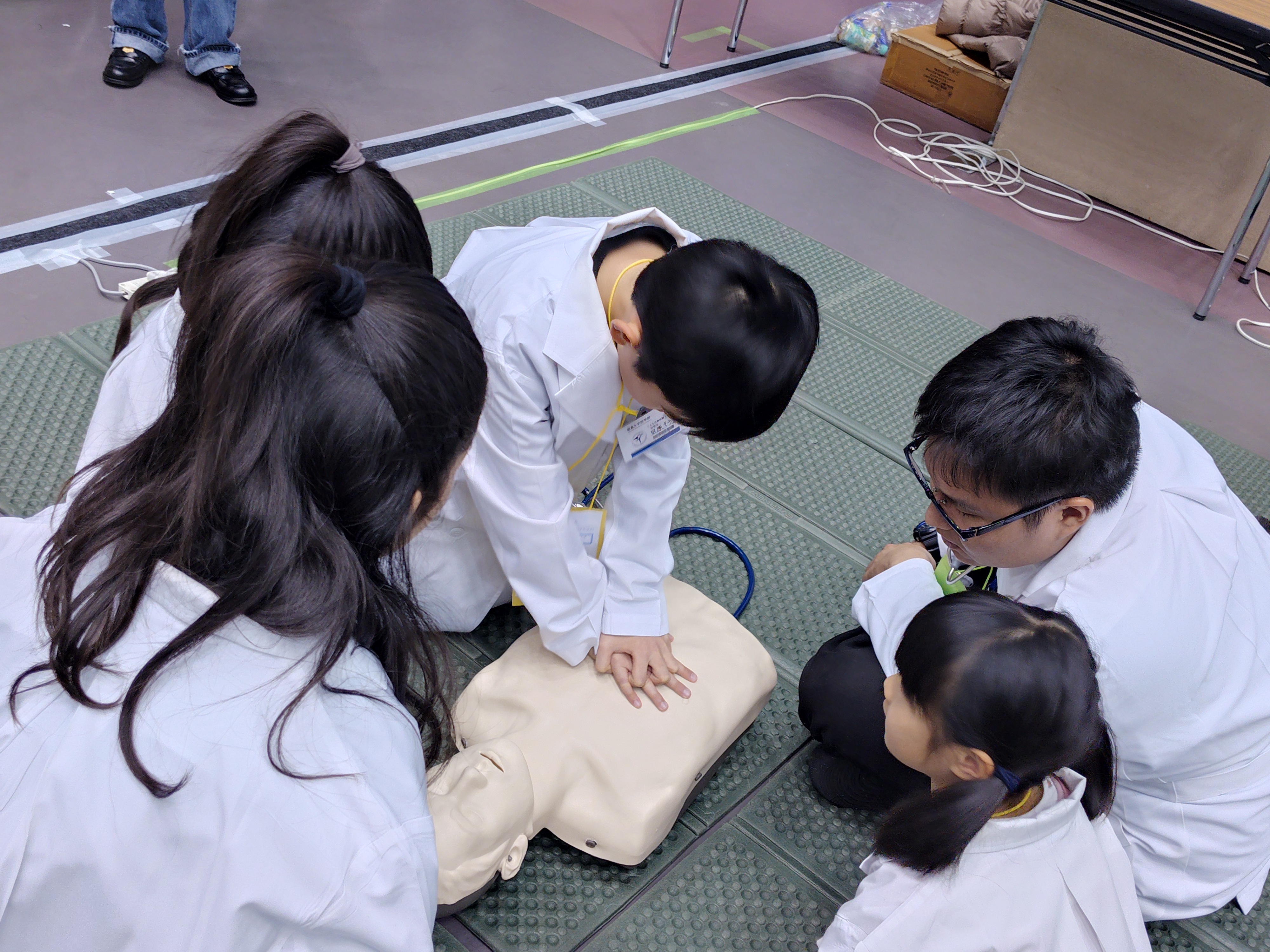 心臓マッサージ体験をする小学生