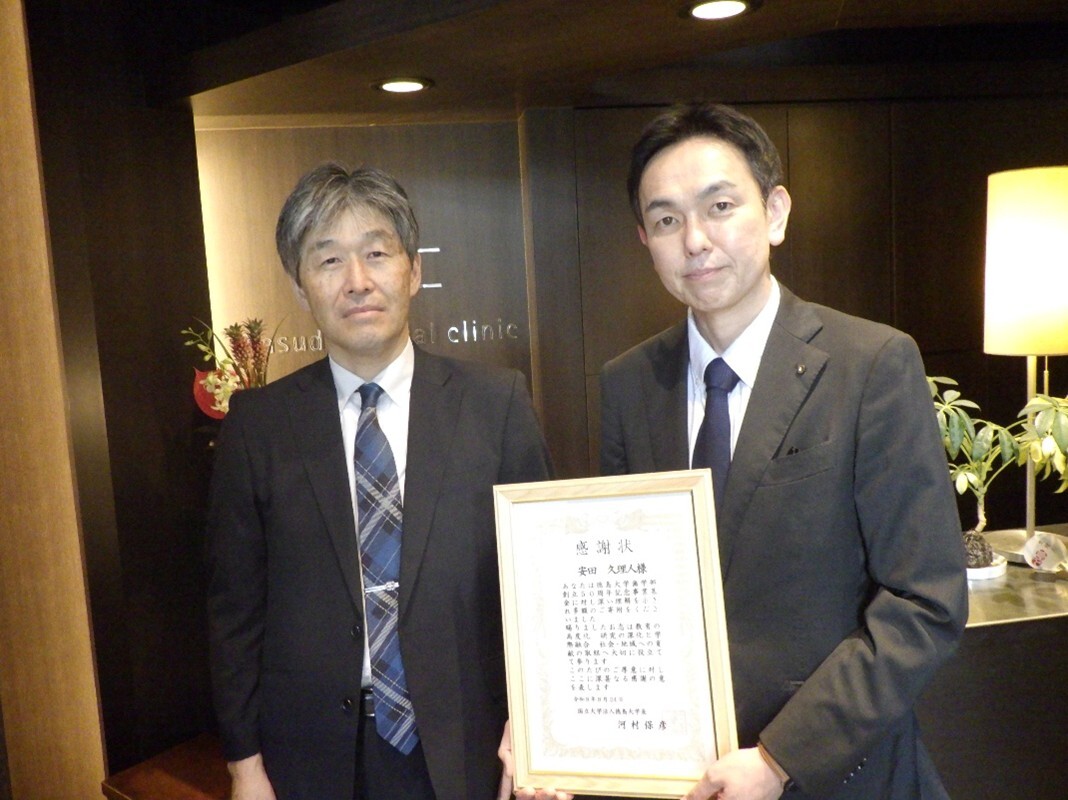安田久理人様(右)と湯本浩通歯学部長(左)記念写真